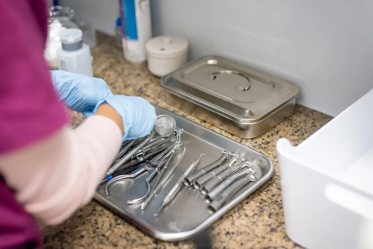 A Dental Korner team member preparing sterilized instruments for a cleaning