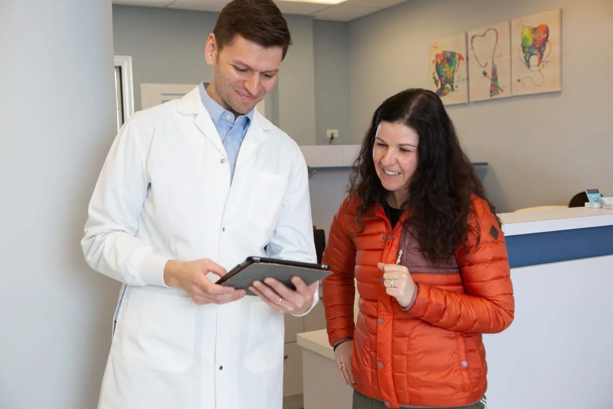Dr. Kroner going over a treatment plan with a patient at the front desk